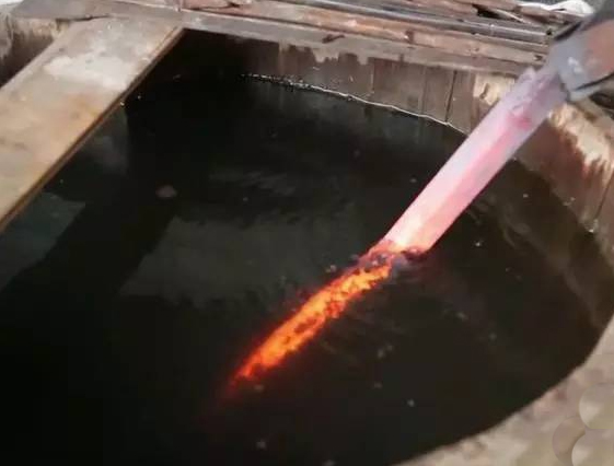 Japanese sword being quenched during the katana hardening process Japanese sword being quenched during the katana hardening process